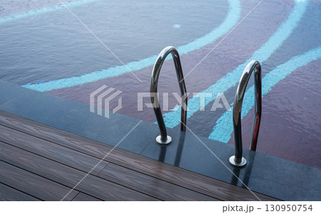 Grab bar ladder in swimming pool Grab bar ladder in swimming pool 130950754