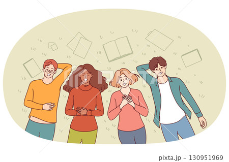 Group of happy students lie on grass in park and smile, enjoying sunny summer day 130951969