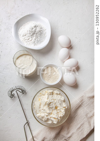 Ingredients for cooking Basque Spanish burnt Saint Sebastian cheesecake. Baking products - cream cheese, sugar, eggs, flour and cream on light background. Recipe step by step flatlay top view Ingredients for cooking Basque Spanish burnt Saint Sebastian cheesecake. Baking products - cream cheese, sugar, eggs, flour and cream on light background. Recipe step by step flatlay top view 130952262