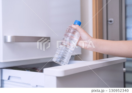 冷蔵庫からペットボトルに入った水を取り出す子供 130952340