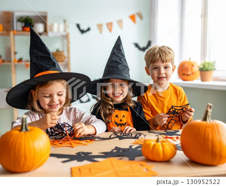 爽やかなミントグリーンの部屋でハロウィン切り絵にチャレンジする笑顔の子どもたち 130952522