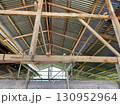 Wooden roof framework with corrugated metal sheets in rustic building 130952964