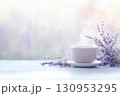 薄紫色のラベンダーの花束と、カップから立ち上る湯気が、穏やかで心地よいアロマテラピーの空間を演 130953295