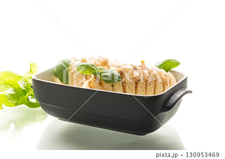 Sliced potatoes in baking dish isolated on white background 130953469