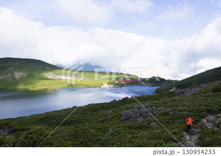美しい白馬大池に向かって歩く登山者 130954233