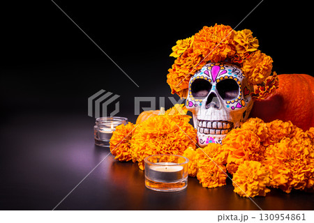 Painted skull with orange marigold flowers.  Dia De Los Muertos holiday. 130954861