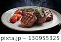Grilled beef steaks with rosemary, salt, and pepper on wooden board. Juicy barbecue meat with spices. Delicious cooked beef fillet on dark rustic background. 130955325