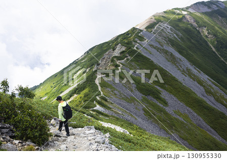 北アルプスの稜線を歩く男性 130955330