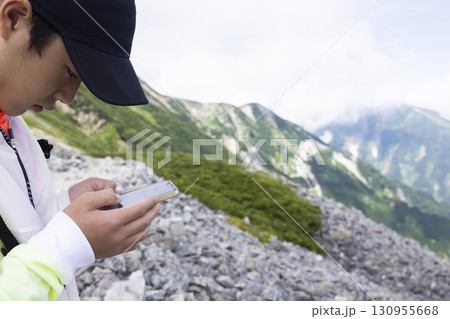 北アルプスの稜線を歩く男性 130955668
