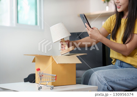Online shopping. Woman taking a photo of a lamp after unboxing. 130956374