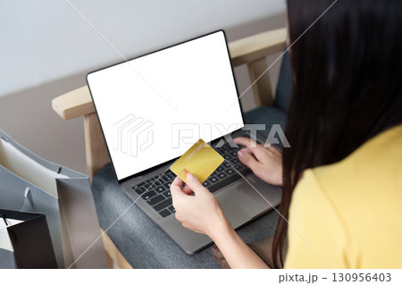 Digital Shopping. Woman holding credit card while using laptop for online purchases. Digital Shopping. Woman holding credit card while using laptop for online purchases. 130956403