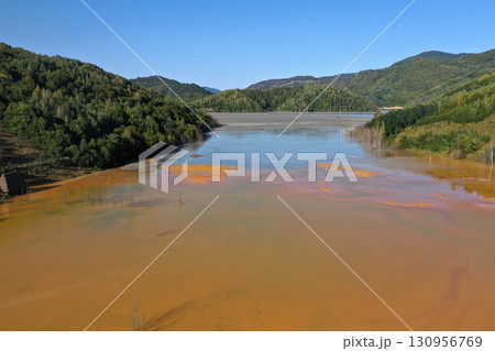 Aerial view of surreal natural patterns of gold cyanide leaching flowing into decanting lake 130956769