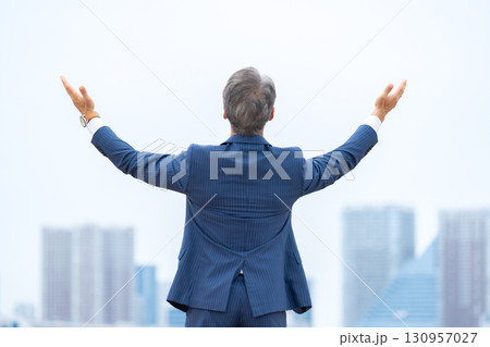 ビジネスマン　ビル群　両手を広げる 130957027