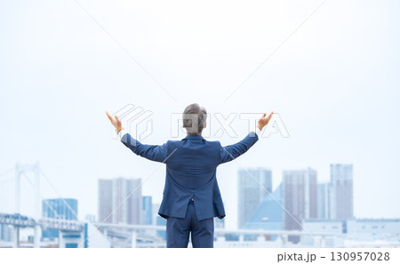 ビジネスマン　ビル群　両手を広げる 130957028