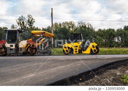 Asphalt rollers and paving machines working together on new road construction site Asphalt rollers and paving machines working together on new road construction site 130958000