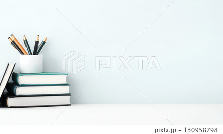 Books and pens arranged neatly on desk, creating calm workspace 130958798