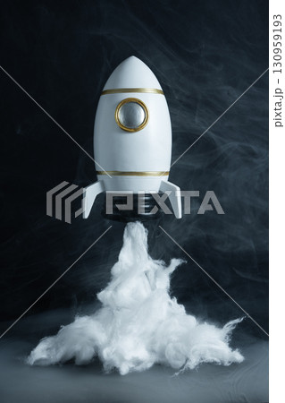 Toy rocket with dense smoke at its base, simulating liftoff, concept of imagination, adventure, and space exploration. Toy rocket with dense smoke at its base, simulating liftoff, concept of imagination, adventure, and space exploration. 130959193