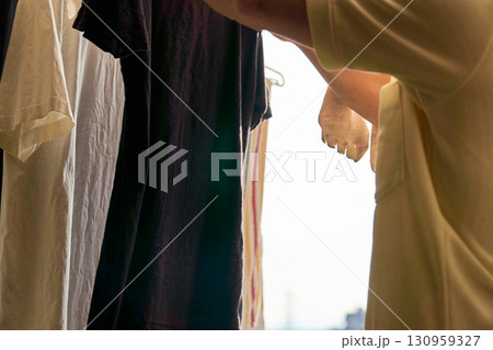 洗濯物を取り入れる男性の連続写真。家事をする男性。 洗濯物を取り入れる男性の連続写真。家事をする男性。 130959327