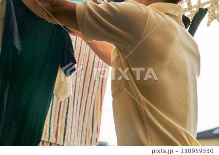 洗濯物を取り入れる男性の連続写真。家事をする男性。 130959330
