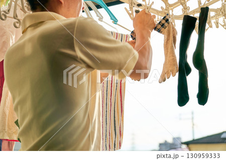 洗濯物を取り入れる男性の連続写真。家事をする男性。 130959333