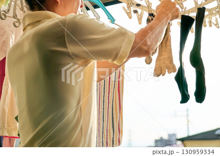 洗濯物を取り入れる男性の連続写真。家事をする男性。 洗濯物を取り入れる男性の連続写真。家事をする男性。 130959334