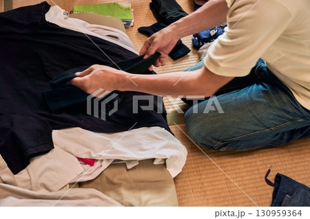 畳に座って洗濯物をたたむ男性の連続写真。家事をする男性。 130959364