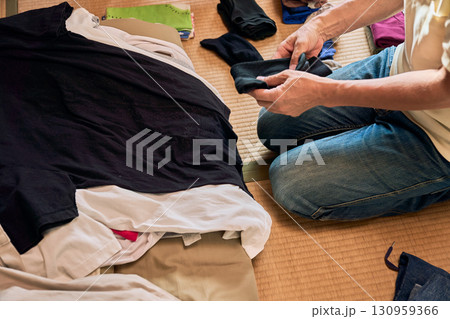 畳に座って洗濯物をたたむ男性の連続写真。家事をする男性。 130959366