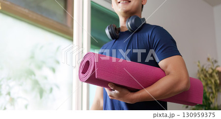 Home Workout. Individual with yoga mat and headphones ready for exercise. 130959375