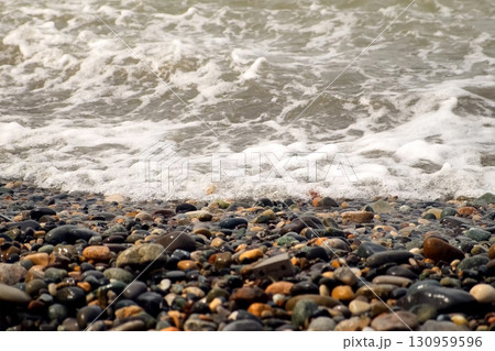 Foamy strong sea waves crashing on pebble beach on Black Sea coast at storm. 130959596
