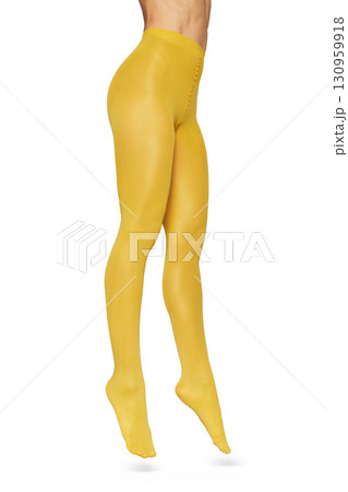 Beautiful long fit female legs in yellow tights jumping on white background 130959918
