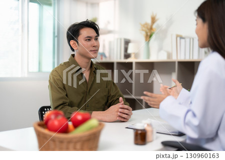 Nutrition Consultation. Male patient discussing health with a dietitian in a modern clinic. 130960163