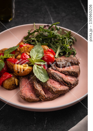 Grilled steak slices with potato tomato arugula Grilled steak slices with potato tomato arugula 130960206