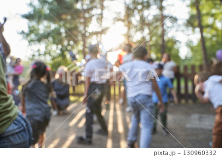 Blurry image of diverse group of children playing outdoors in sunlit park Blurry image of diverse group of children playing outdoors in sunlit park 130960332
