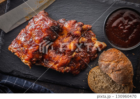 Pork BBQ glazed ribs and sauce on black table. Top view. 130960470
