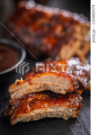 Pork BBQ glazed ribs on black table. Pork BBQ glazed ribs on black table. 130960474
