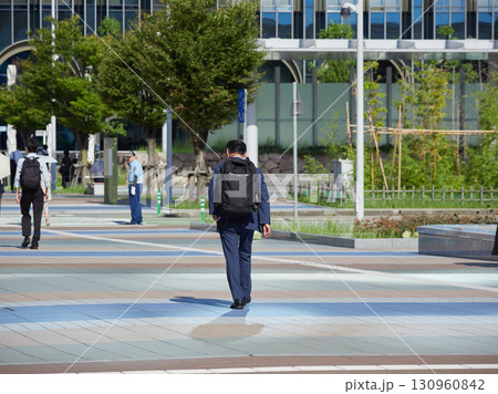 夏の朝の金沢駅西広場を渡る通勤中の男性会社員の姿 130960842