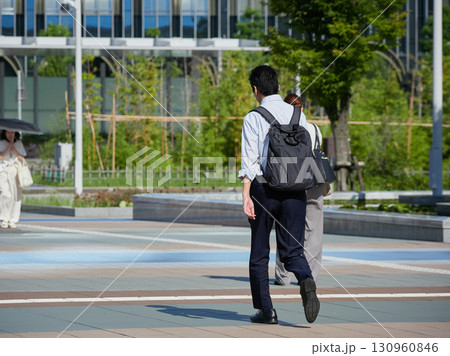 夏の朝の金沢駅西広場を渡る通勤中の男性会社員の姿 130960846