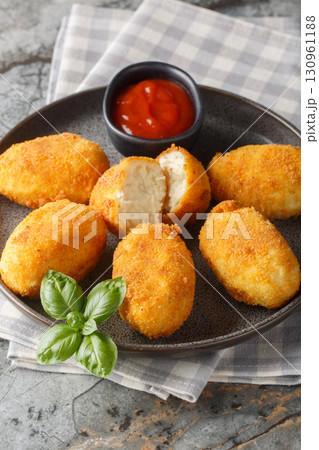 Chicken Croquettes Croquetas de Pollo with ketchup close-up in a plate. Vertical 130961188