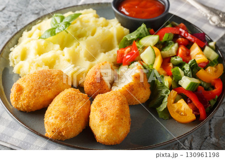 Breaded and fried chicken Croquettes served with mashed potatoes, fresh salad and tomato sauce close-up in a plate. Horizontal Breaded and fried chicken Croquettes served with mashed potatoes, fresh salad and tomato sauce close-up in a plate. Horizontal 130961198