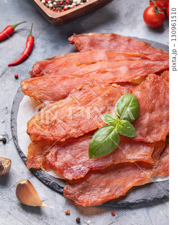Dried chicken meat on stone tray with fresh basil leaf and various spices on table Dried chicken meat on stone tray with fresh basil leaf and various spices on table 130961510
