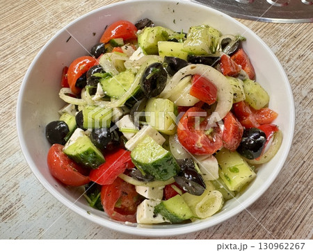 A vibrant Mediterranean salad featuring tomatoes, cucumbers, olives, and feta cheese, perfect for any meal. Close-up. 130962267