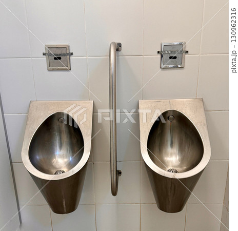The sleek, modern, and hygienic design of stainless steel urinals is ideal for use in public bathrooms and toilets. 130962316
