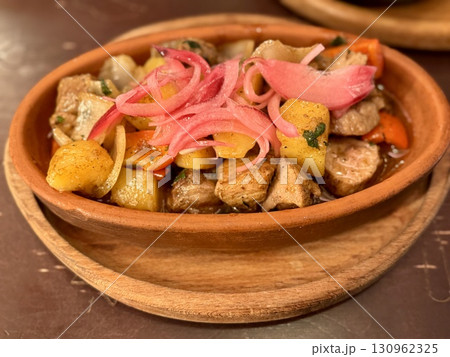 This dish features flavorful pork, paired with roasted vegetables and mango pickled onions for an exquisite meal next to glass beer. Close-up. 130962325