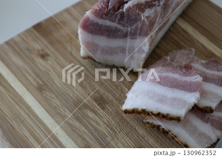 Ukrainian traditional cuisine. Very tasty pieces of salo. Raw ukrainian bacon or salo on wooden board. Sliced salted pork lard (salo). Food concept. 130962352
