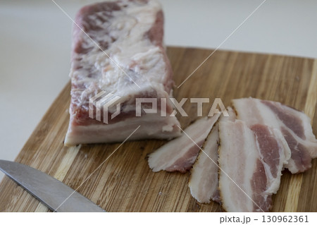 Ukrainian traditional cuisine. Very tasty pieces of salo. Raw ukrainian bacon or salo on wooden board. Sliced salted pork lard (salo). Food concept. 130962361