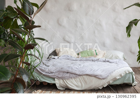 Mindful living space with a cozy bed surrounded by greenery in a tropical hotel room Mindful living space with a cozy bed surrounded by greenery in a tropical hotel room 130962395
