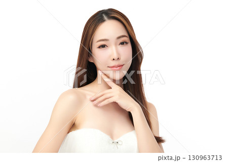 A beautiful young Asian woman with clean, fresh skin against a white background. Skincare, facial treatment, cosmetology, beauty, and spa. An elegant portrait of an Asian woman. 130963713