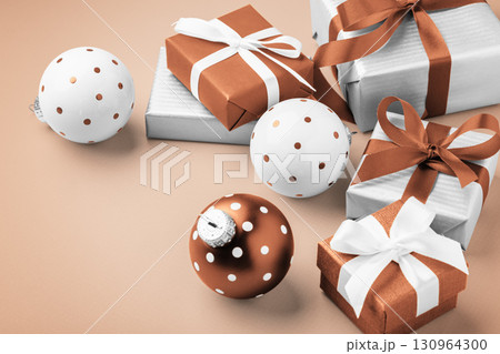 Gift boxes, present with brown bow ribbon and christmas ball decor, christmas holiday light brown background Gift boxes, present with brown bow ribbon and christmas ball decor, christmas holiday light brown background 130964300