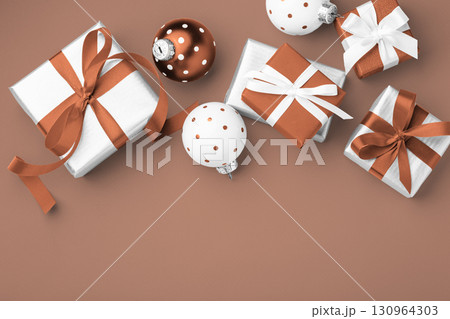 Christmas holiday mocha mousse color background, Gift boxes with brown bow ribbon and christmas ball decor, top view Christmas holiday mocha mousse color background, Gift boxes with brown bow ribbon and christmas ball decor, top view 130964303