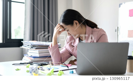 Working Asian women feel stressed, tired from work, migraine headaches from hard work while working at the office 130965117